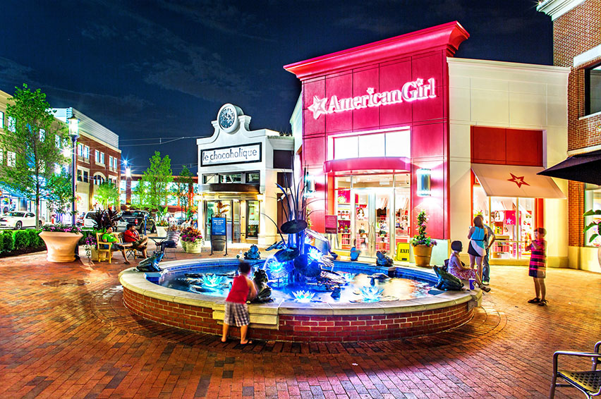 Fountain in front of American Girl store's pink storefront