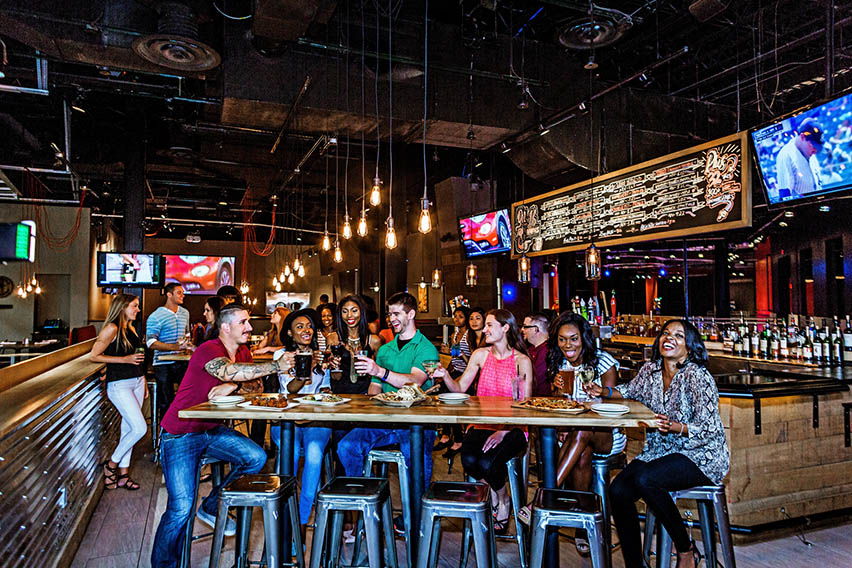 Group of young adults doing a cheers at World of Beer at Easton Town Center