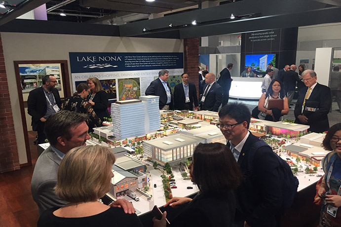 Lake Nona model surrounded by onlookers at a conference