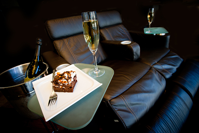 Plated dessert and glass of Dom Perignon champagne on a lounge movie theatre seat at Cinepolis