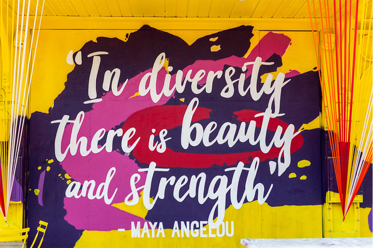 Art mural on a wall that says "In diversity there is beauty and strength"