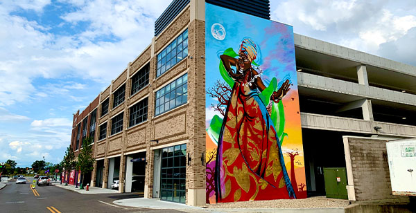 Bright, colorful mural painted on side of three-story garage.