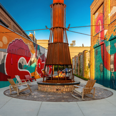 Outdoor heater in an alley surrounded by art murals on the walls
