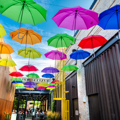 Rainbow umbrellas hanging over the street at Easton Gateway